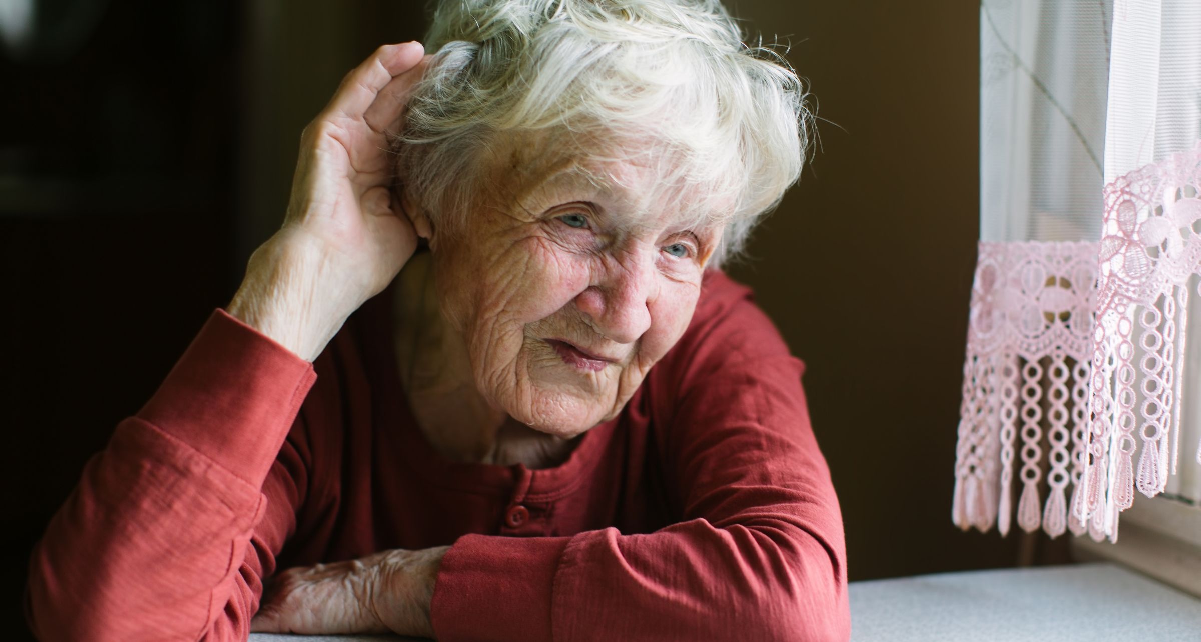 signora anziana mano orecchio